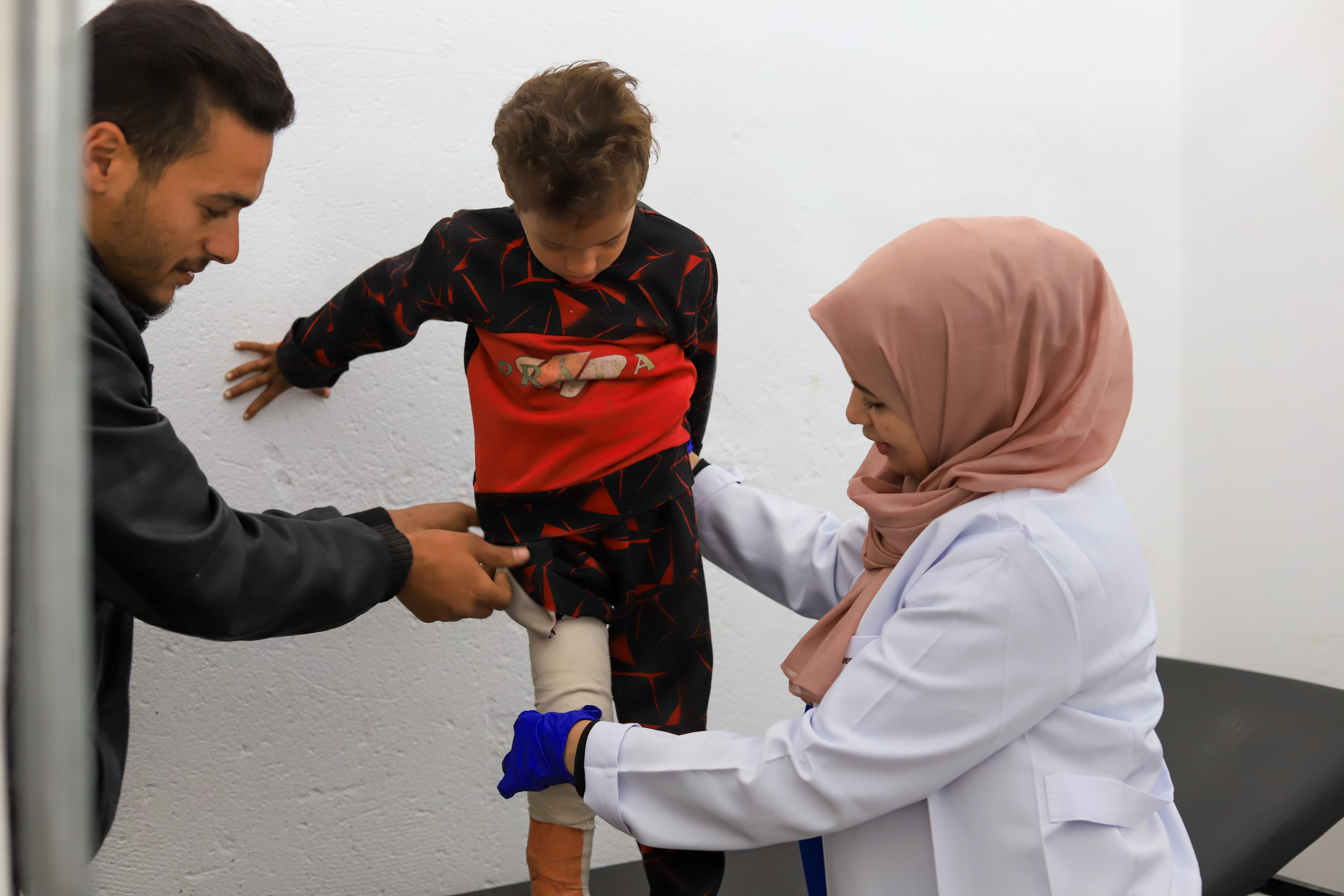 Een jongen en zijn vader worden geholpen bij de dokter