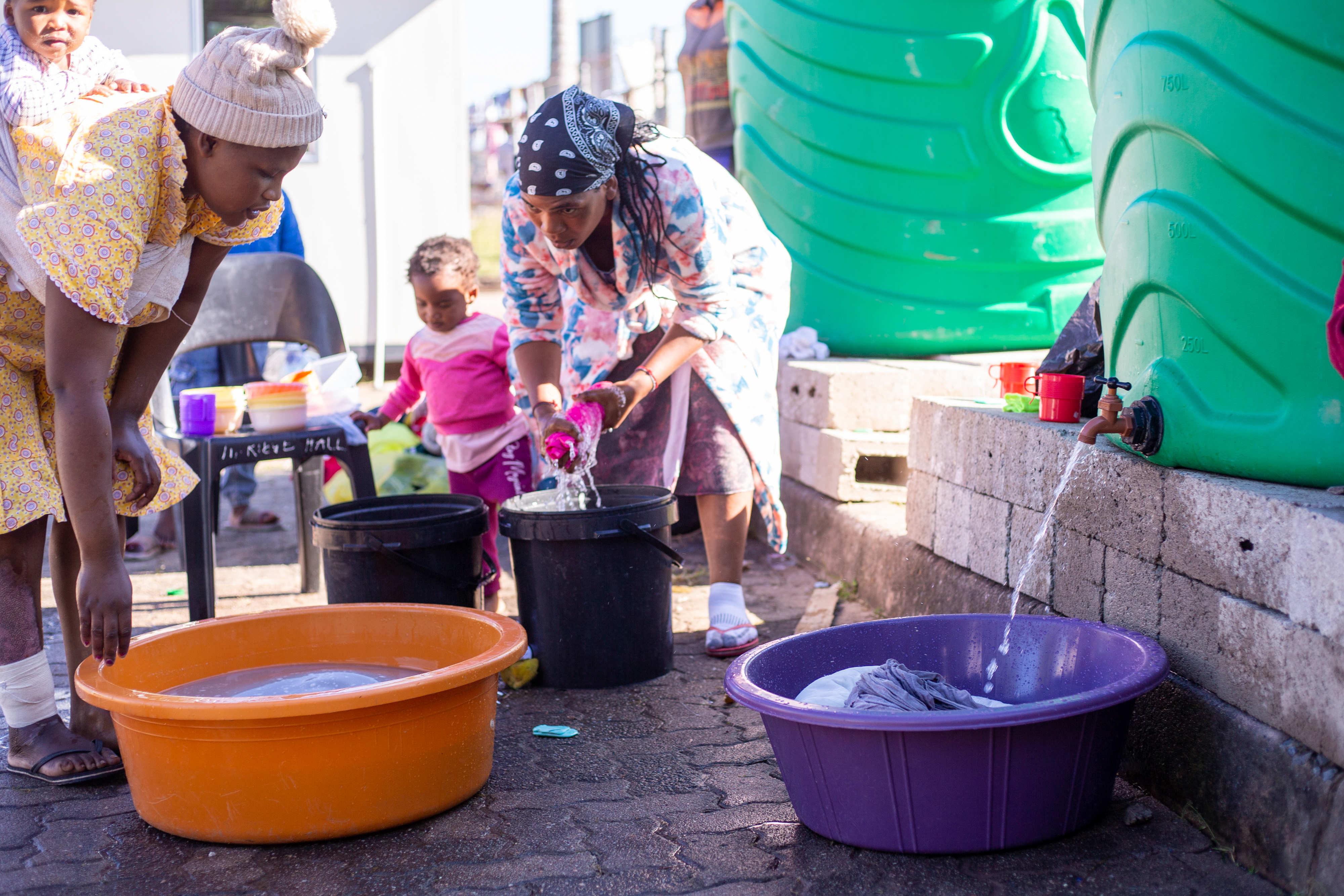 vrouwen nemen water uit tonnen