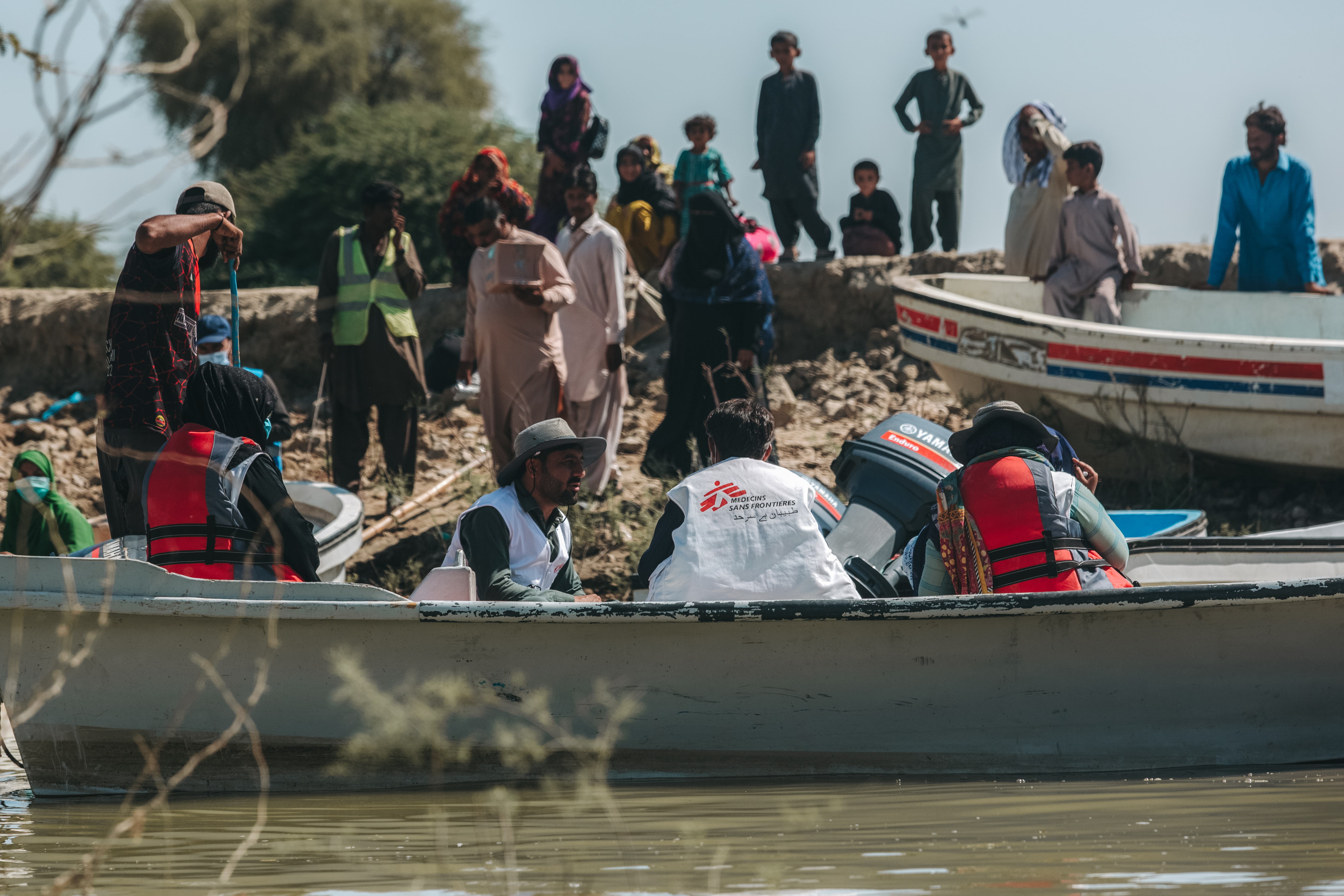 Mensen op het droge en in boten op het water