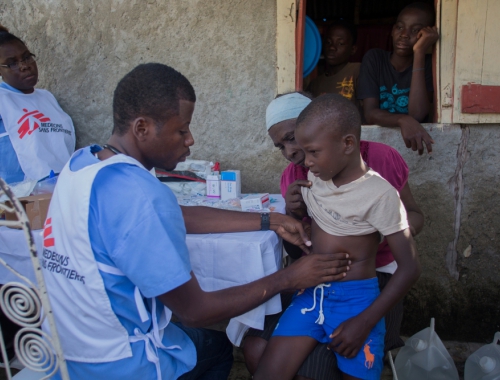 Le médecin Medjy examine un petit garçon de cinq ans qui est accompagné par sa grand-mère à Coteaux © Jeanty Junior Augustin. Haïti, 2016.